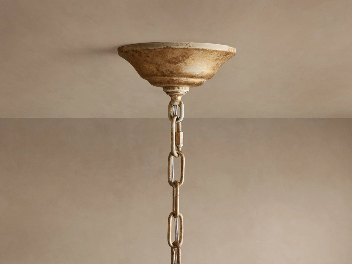 Close-up of Nicoletta Round Chandelier featuring gold metallic leaves, clear crystal accents, and warm glowing bulbs.