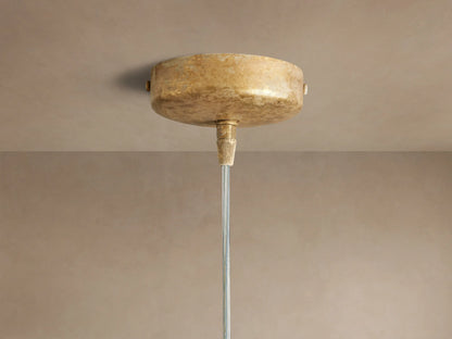 Close-up of the Lorca Pendant, with overlapping, textured gold/bronze petal-like layers & a warm glowing bulb.
