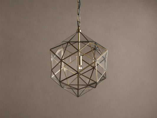 Eliana Lantern Pendant: Geometric brass and clear glass lantern hanging from a black chain, with a light bulb inside.