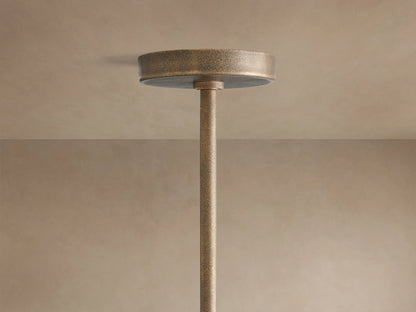 Emmet Round Chandelier, close-up. Textured antiqued brass ring and vertical arms with glowing filament bulbs.