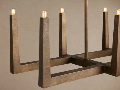 Emmet Linear Chandelier: Antiqued brass finish, rectangular frame with 8 upright light stems, against a light background.