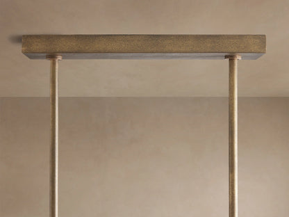 Close-up Emmet Linear Chandelier: textured antiqued bronze linear frame with upright arms, glowing LED filament bulbs.