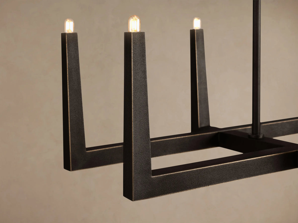 Emmet Linear Chandelier, dark textured antiqued brass/bronze. Rectangular linear frame with small upward-facing lights.