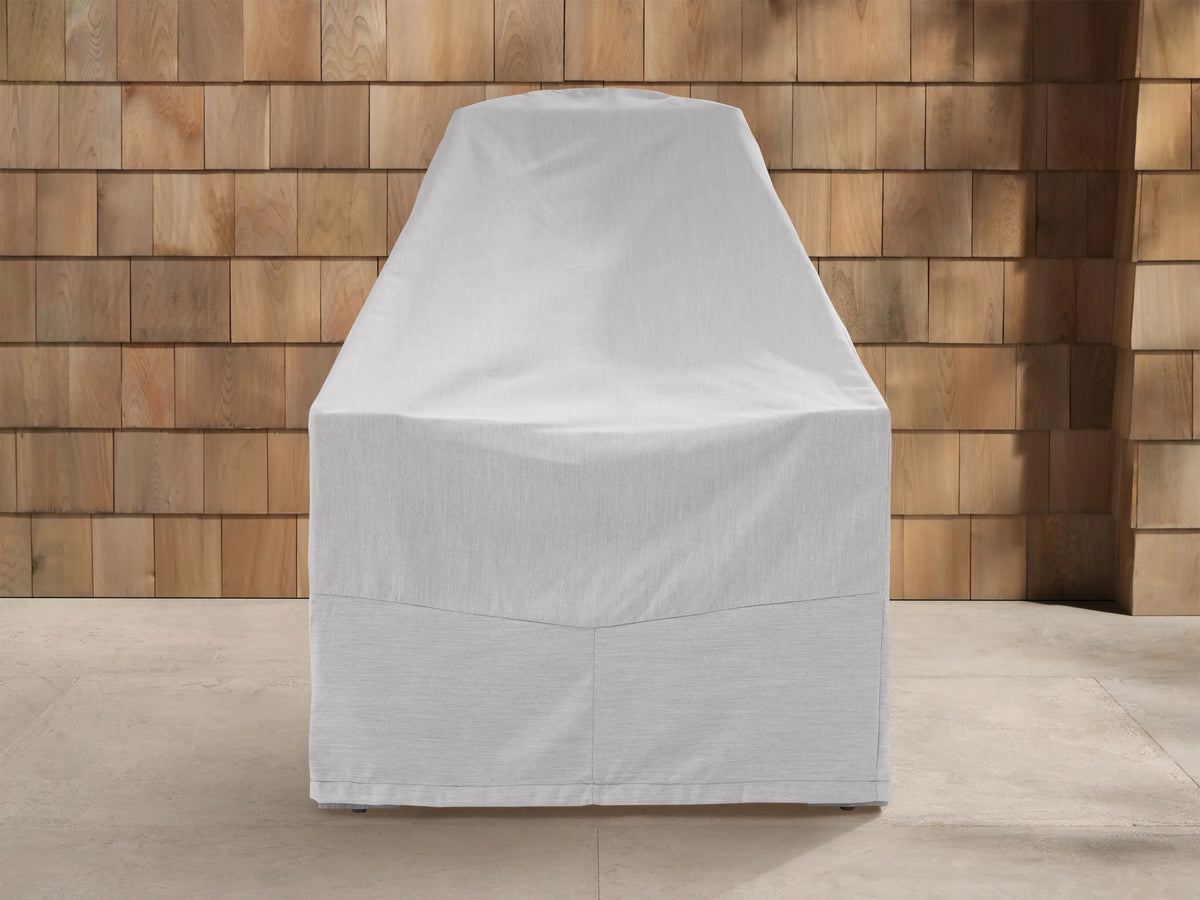 Three light grey Adirondack outdoor furniture covers: sofa, table, armchair on patio against wood shingle wall.