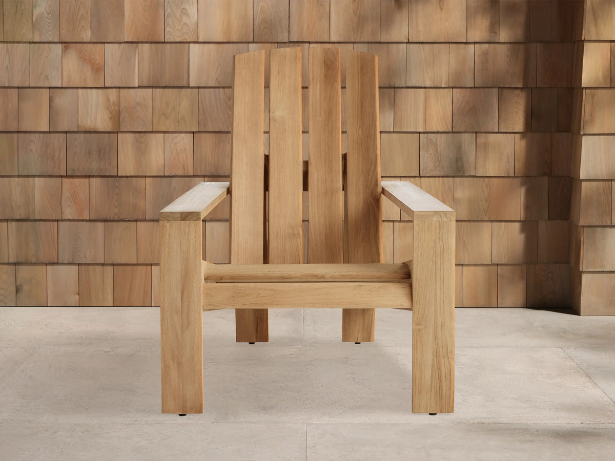 Light gray Agora?? Adirondack Outdoor Collection Cover with subtle texture, draped over furniture. Wood shingle wall background.