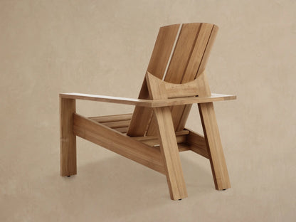 Angled close-up of an Adirondack Outdoor Lounge Chair, showing untreated golden teak wood slats, natural grain, and joinery details.