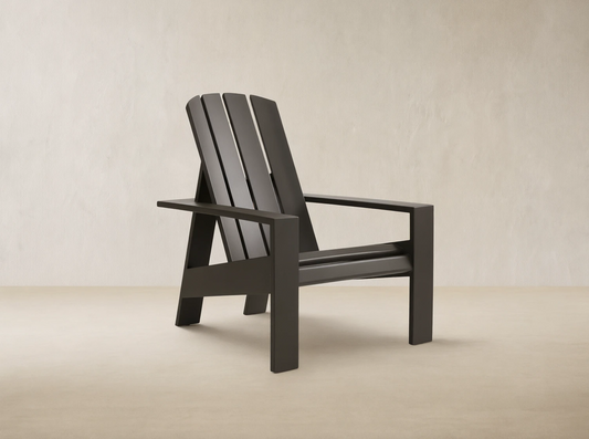Powder-coated dark bronze Adirondack outdoor aluminum lounge chair, angled against a wooden shingle wall on light pavement.
