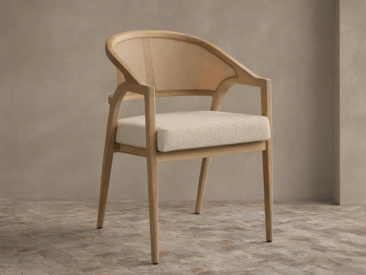 Front view of the Aimee Outdoor Dining Chair with a natural teak frame, light woven caning backrest, and a light beige cushion.