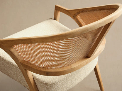 Front view of the Aimee Outdoor Lounge Chair featuring a light teak wood frame, woven resin caning back, and a textured beige cushion.