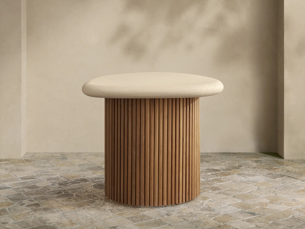 Alesso Outdoor End Table: beige, rounded top on a cylindrical base of natural wood slats, on a light stone floor.