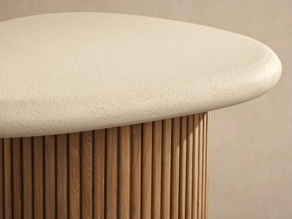 Alesso Outdoor End Table: cream organic-shaped concrete top, natural teak wood slatted cylindrical base on stone floor.