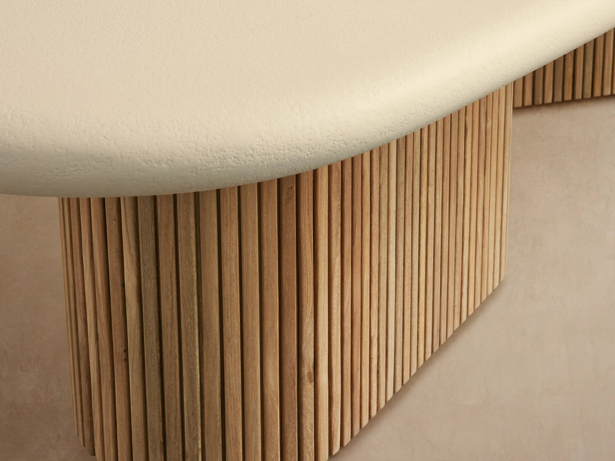 Alesso Outdoor Coffee Table: Light cream oval top, two bases of vertical light brown wood slats on stone patio.
