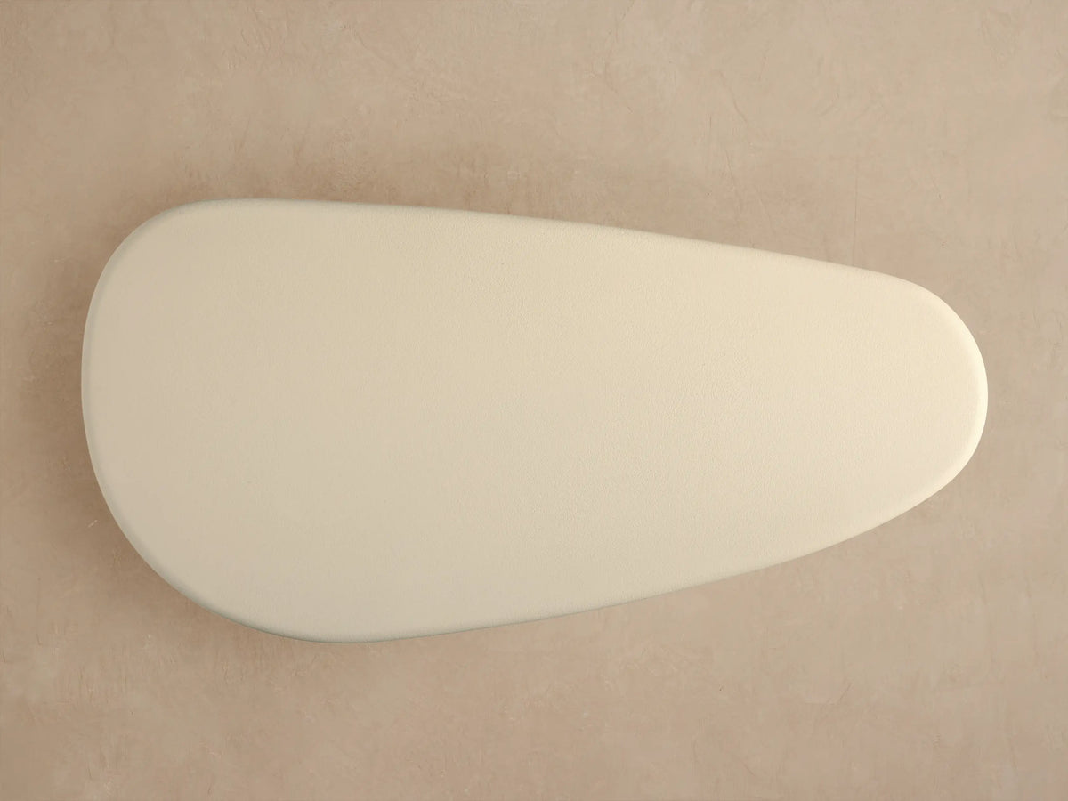 Close-up of Alesso Outdoor Coffee Table showing textured cream top and curved base of vertical natural wood slats.