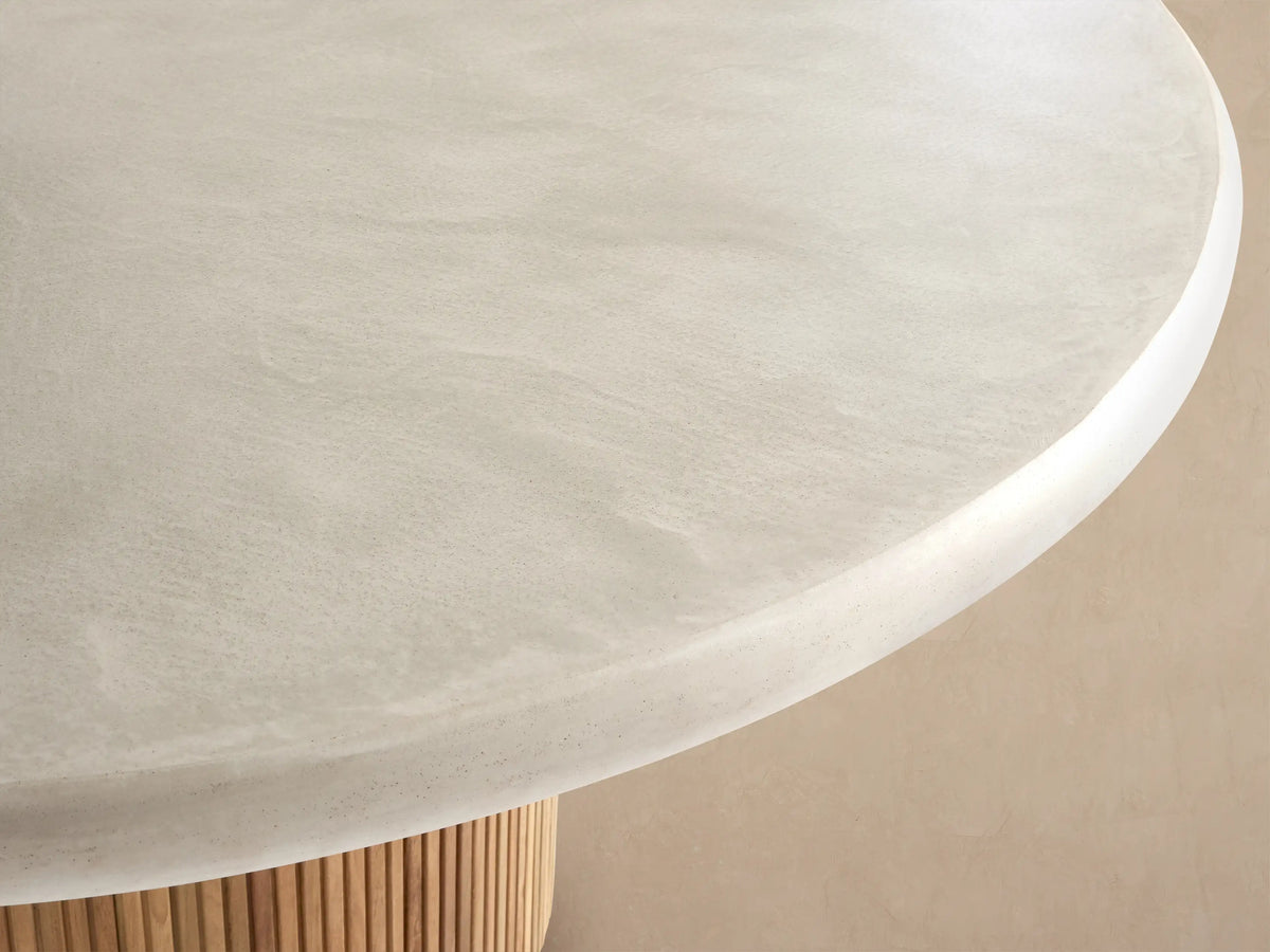 Alesso Outdoor Round Dining Table, cream concrete composite top, light brown fluted reclaimed teak wood cylindrical base.