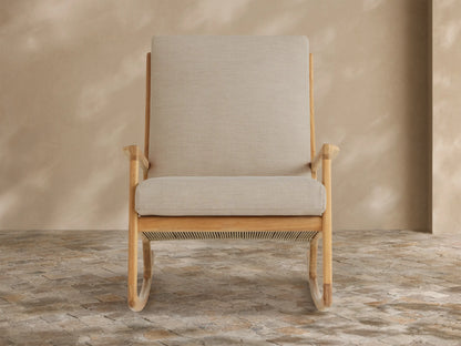 Light grey tailored Altea Outdoor Collection Cover on furniture, front view, against a beige wall and stone floor.