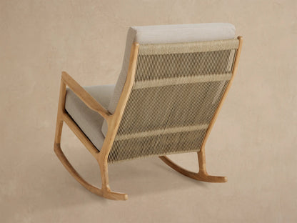 Altea Outdoor Rocking Chair, close-up angled view showing light beige cushions, natural teak wood frame & woven tan rope back.