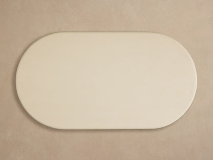 Anami Outdoor Coffee Table. Close-up of light cream rounded top on a distressed light teak wood base with visible grain.