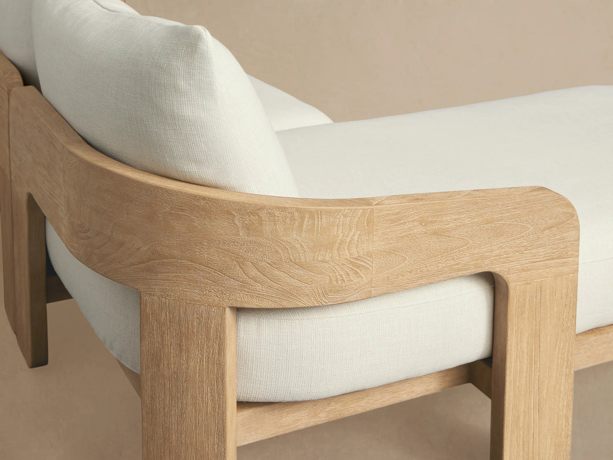 Anami Outdoor L-shaped Two-Piece Chaise Sectional with natural teak wood frame and plush off-white cushions on a patio.