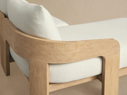 Anami Outdoor L-shaped Two-Piece Chaise Sectional with natural teak wood frame and plush off-white cushions on a patio.