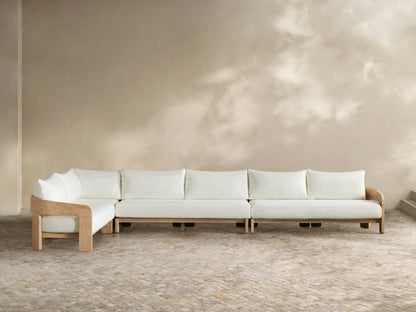 Anami Outdoor L-shaped corner sectional. Light teak wood frame with white cushions. A corner piece & two straight sections on tiled floor.