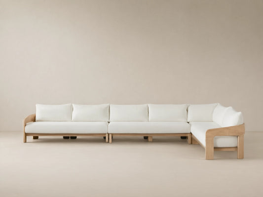 Anami Outdoor L-shaped corner sectional. Light teak wood frame with white cushions. A corner piece & two straight sections on tiled floor.