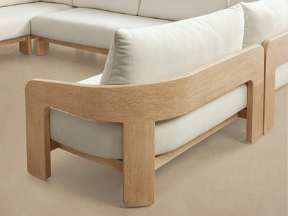 Front view of the L-shaped Anami Outdoor Three-Piece Sectional, featuring a light teak wood frame and plush white cushions.