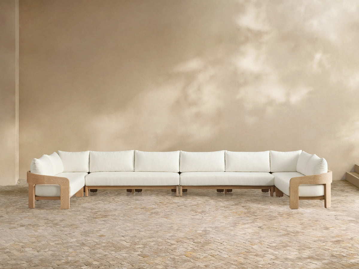 Front view of the Anami Outdoor Four-Piece Sectional with natural teak wood frame and white cushions.
