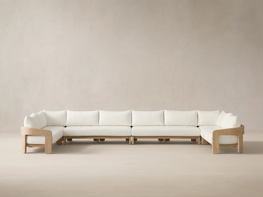 Front view of the Anami Outdoor Four-Piece Sectional with natural teak wood frame and white cushions.