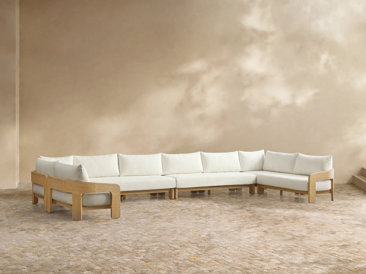 Front view of the Anami Outdoor Four-Piece Sectional with natural teak wood frame and white cushions.