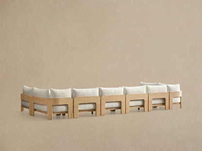 Side profile of the Anami Outdoor Four-Piece Sectional, showing a light teak wood frame and cream cushions.