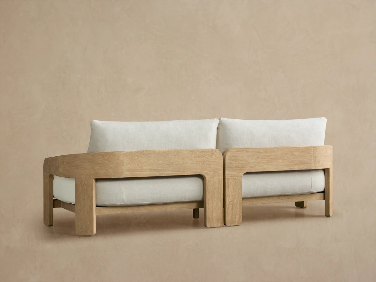 Anami Outdoor Sofa, close-up of two light wood frame sections with textured cream cushions.