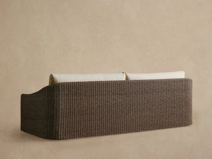 Ancona Outdoor Sofa close-up: light beige back cushion and textured dark brown handwoven all-weather wicker armrest.