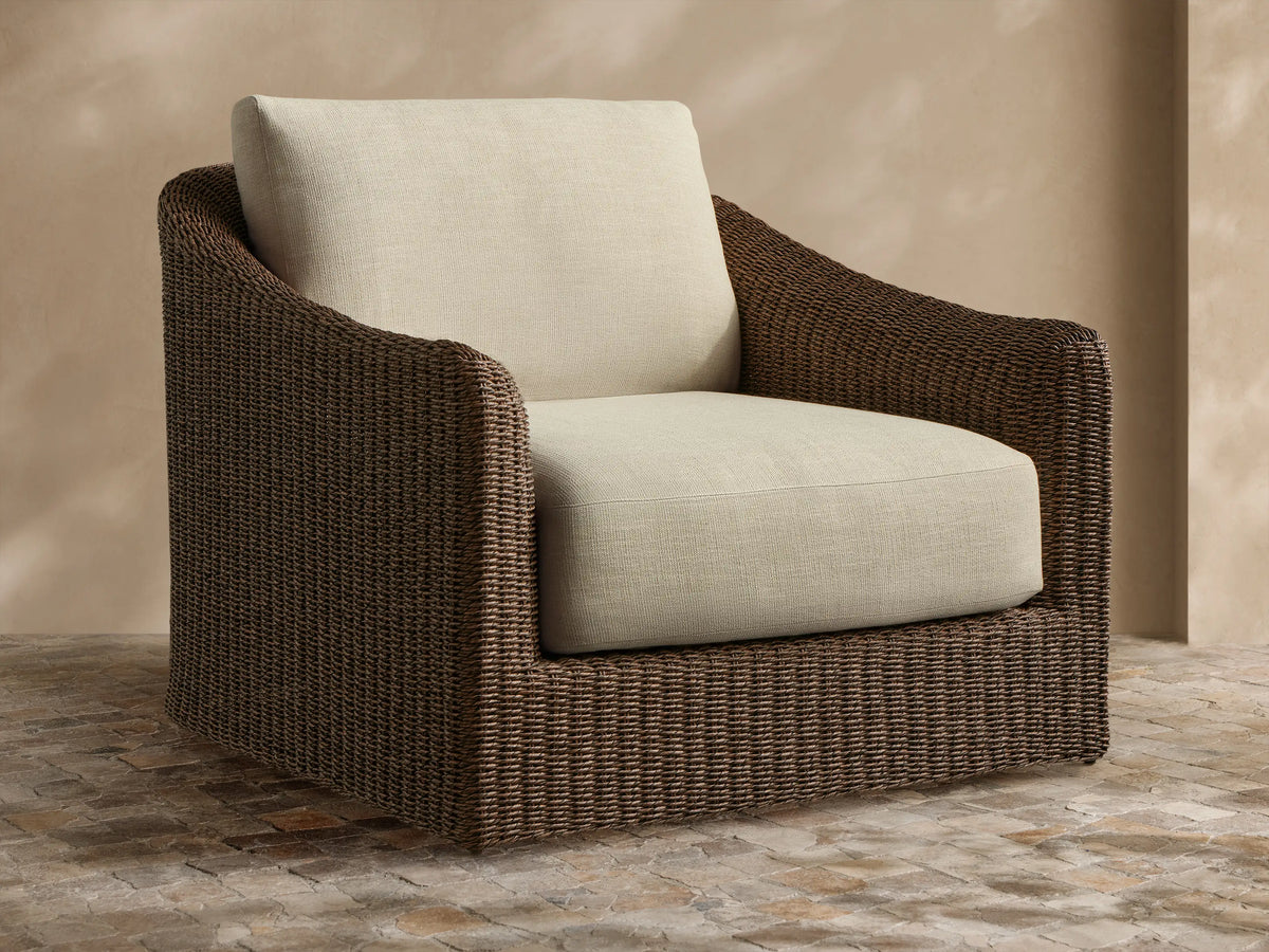 Ancona Outdoor Swivel Chair. Dark brown handwoven wicker body with thick, light beige seat and back cushions, angled right.