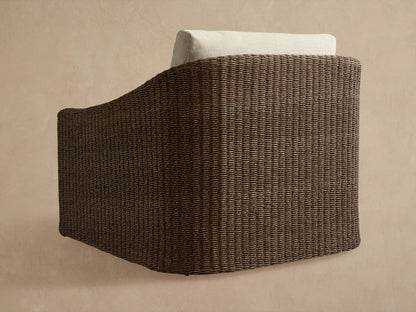 Ancona Outdoor Swivel Chair, side view, dark brown handwoven all-weather wicker with a light cream back cushion.