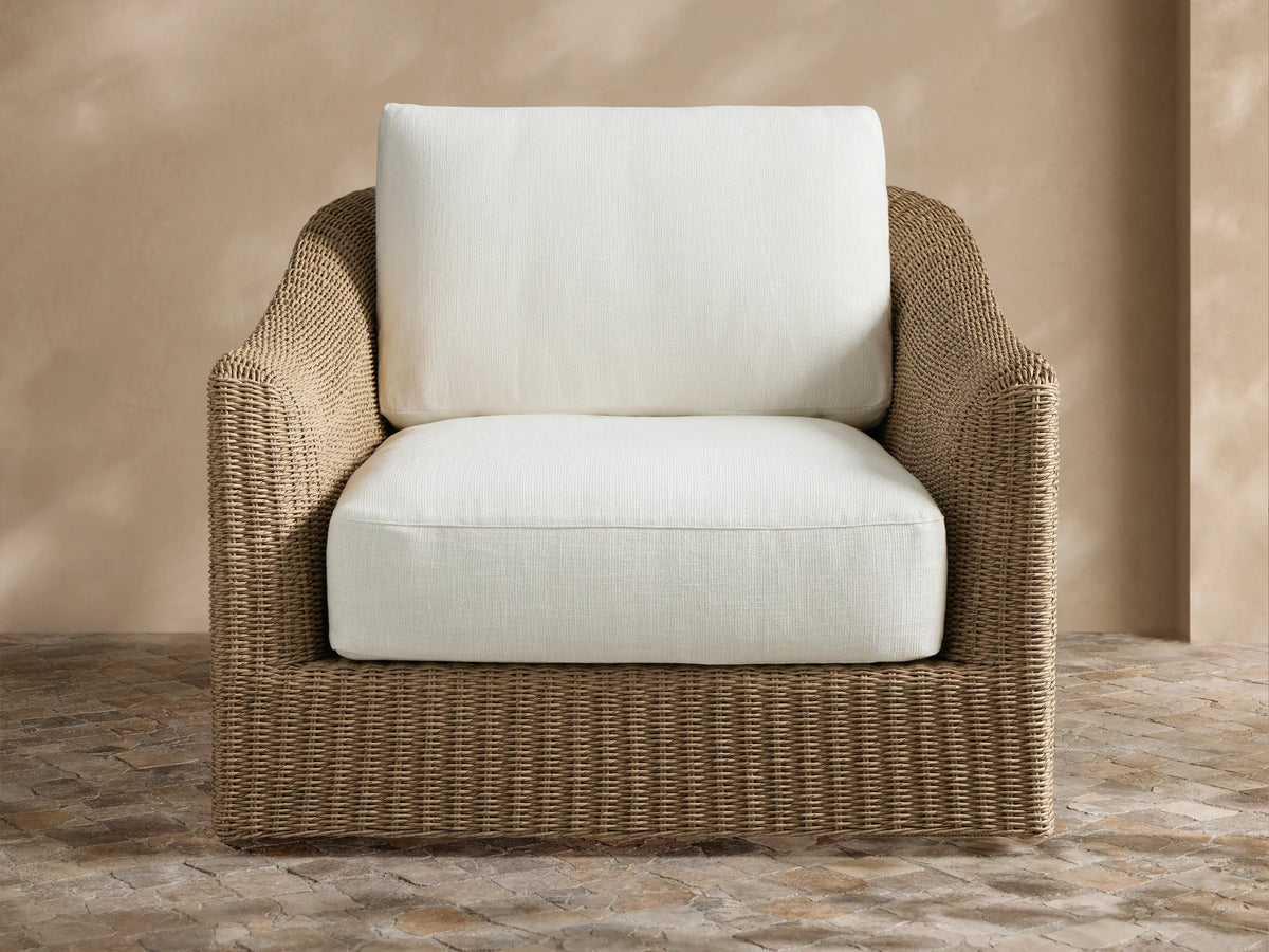 Front view of brown woven Ancona Outdoor Swivel Chair with light beige cushions in an outdoor patio setting.