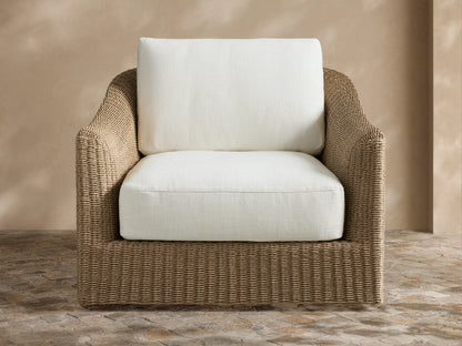 Front view of brown woven Ancona Outdoor Swivel Chair with light beige cushions in an outdoor patio setting.