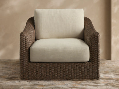 Light grey Ancona Outdoor Collection Cover on a chair, showing subtle texture & front seam, on a stone patio.