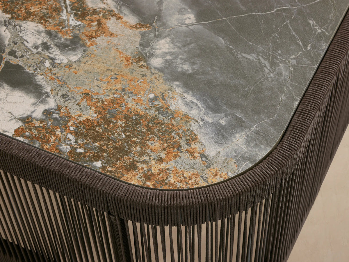 Anzio Outdoor Coffee Table with dark brown handwoven rope base & rectangular dark gray sintered stone top with white & gold veining.