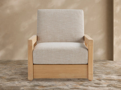 Front view of light grey Westport Outdoor Collection Cover. Tailored, textured fabric with a front seam, against a tan wall on a stone patio.