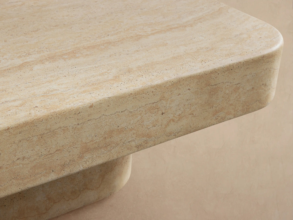 Azores Outdoor Coffee Table: Light beige rectangular, low-profile faux travertine finish with rounded edges, on tiled floor.