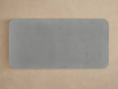 Close-up of Azores Outdoor Coffee Table's rounded corner, showing its rough, light grey, concrete-like surface texture.