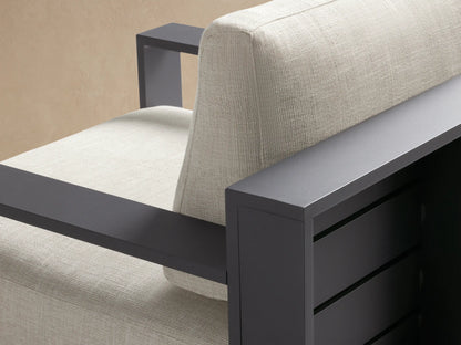 Modern dark gray aluminum Bal Harbour swivel chair with thick light beige cushions on a stone patio.