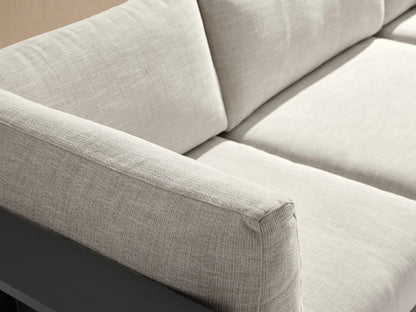 Bal Harbour L-shaped outdoor aluminum sectional with dark gray frame, light beige cushions, and side shelves, on a patio.