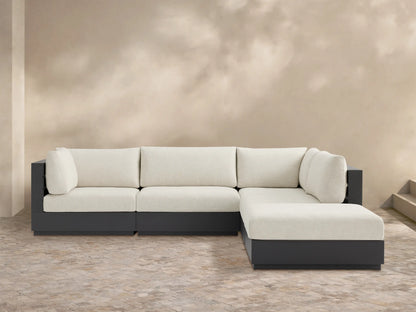 Bal Harbour Outdoor L-shaped sectional with ottoman. Dark gray aluminum frame, light cream cushions on a patterned patio floor.