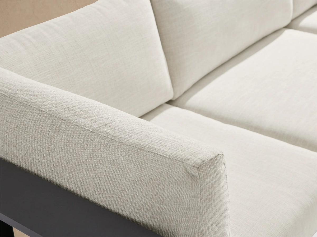Bal Harbour outdoor aluminum 5-pc sectional in L-shape with dark gray frame, light cushions, built-in shelf, & ottoman on patio.