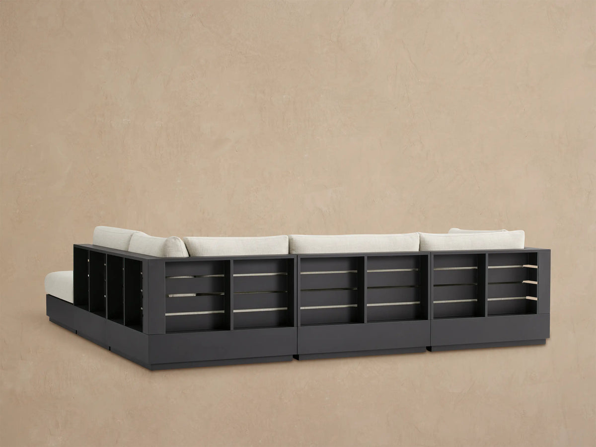 Bal Harbour Outdoor Sectional, close-up of light beige textured fabric armrest & cushions over dark aluminum frame.