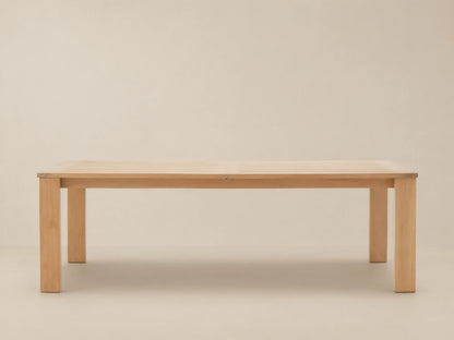 Bal Harbour Outdoor Teak Extension Dining Table, light teak wood with slatted top and sturdy legs, on a stone patio.