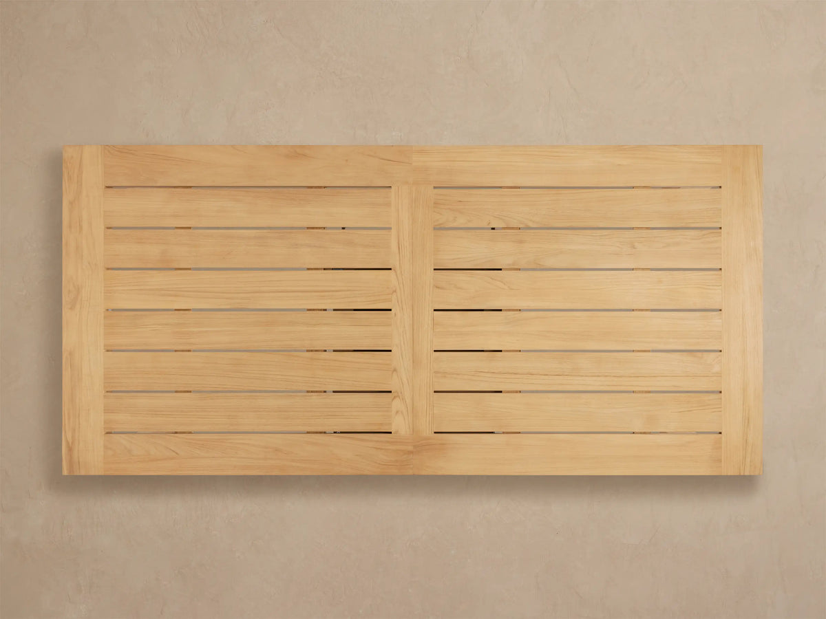Close-up of Bal Harbour Outdoor Teak Dining Table corner, showing light golden teak wood planks with visible grain.