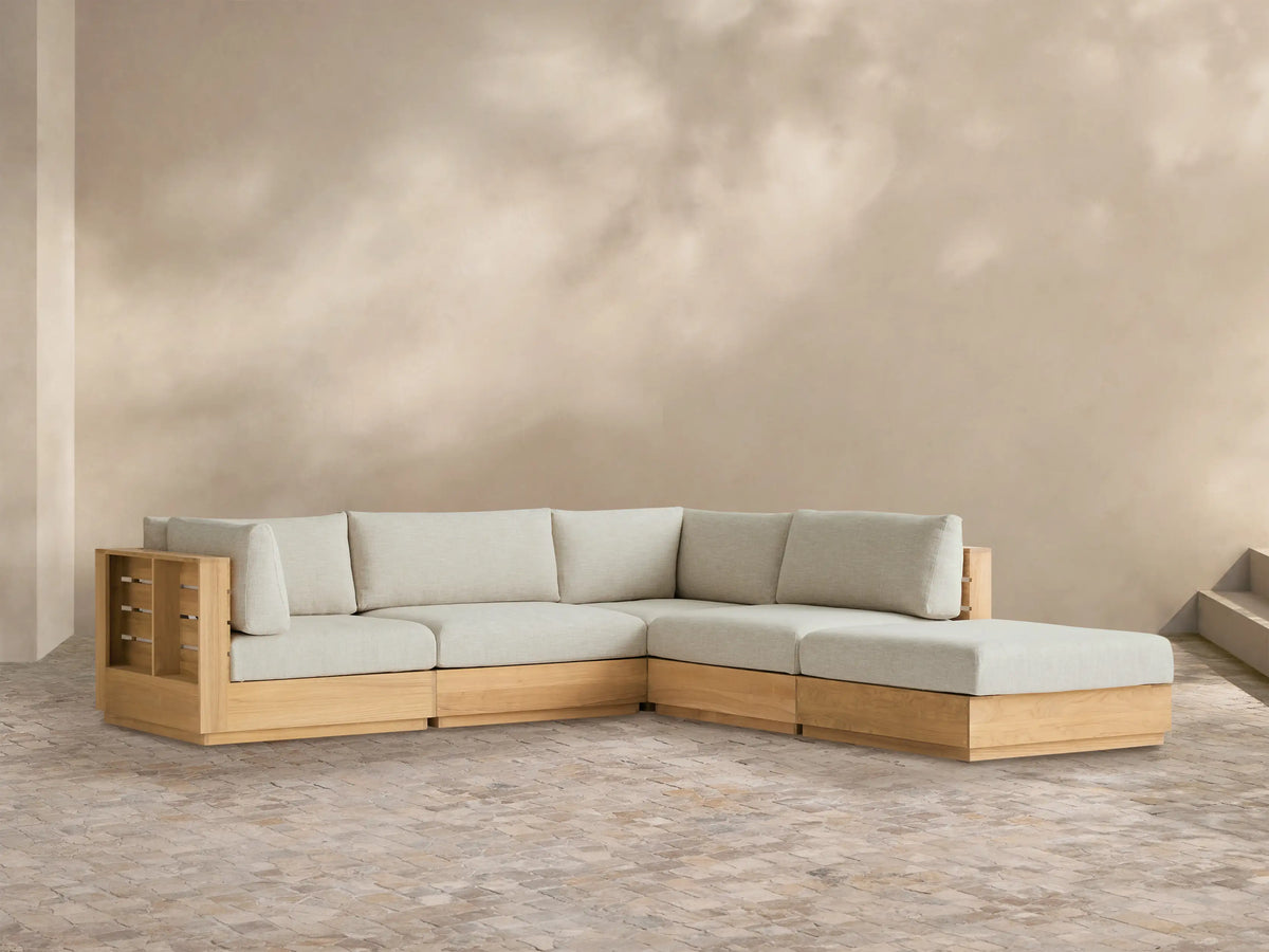 Bal Harbour Outdoor Teak Five-Piece Sectional with Ottoman, light teak frame & light beige cushions in L-shape on tiled patio.