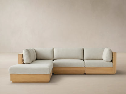 Bal Harbour Outdoor Teak Five-Piece Sectional with Ottoman, light teak frame & light beige cushions in L-shape on tiled patio.